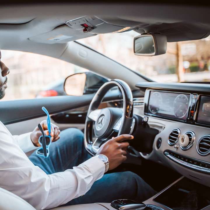 Uomo in camicia abito bianco che guida auto durante il giorno puzzle scorrevole online