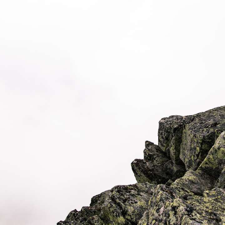Montaña rocosa gris bajo el cielo blanco durante el día puzzle deslizante online