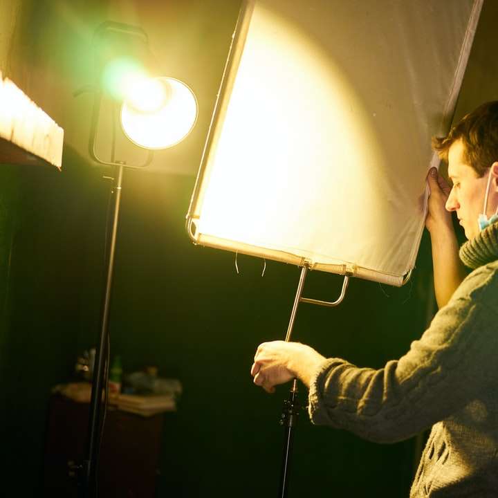 Muž v černé bundě drží bílé a černé podlahové lampy online puzzle