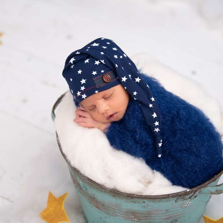 Fille en bonnet en tricot bleu et veste bleue sur le champ couvert de neige puzzle en ligne