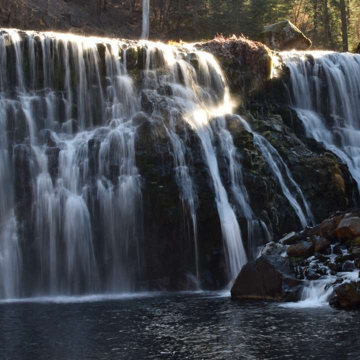 water falls on brown rocks online puzzle