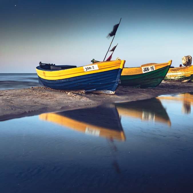 Barca gialla e verde sull'acqua durante il giorno puzzle scorrevole online