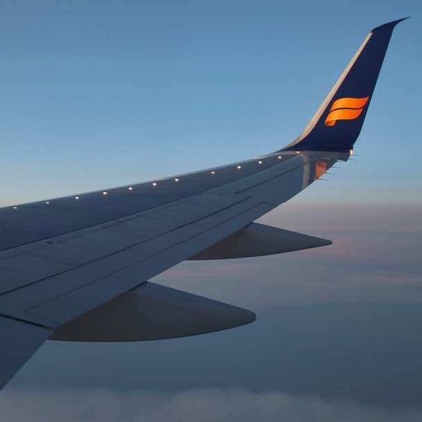 Skrzydło samolotowe pod błękitnym niebem w ciągu dnia puzzle przesuwne online