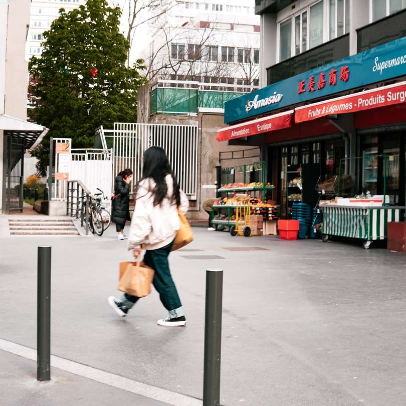 Жена в бяло яке седи на сива бетонна пейка онлайн пъзел
