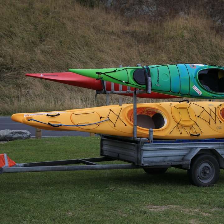 Κίτρινο και πράσινο ξύλινο σκάφος σε γκρι άσφαλτο δρόμο online παζλ