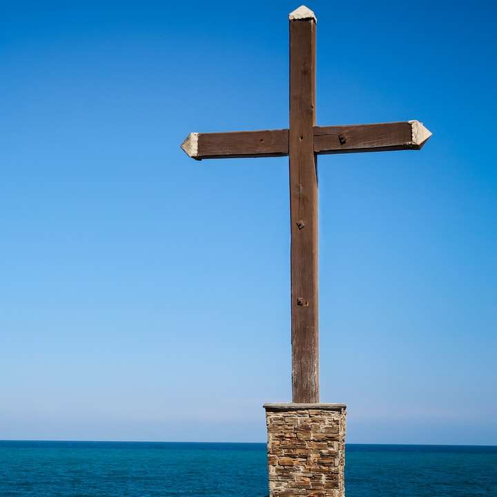 brown wooden cross on beach during daytime online puzzle