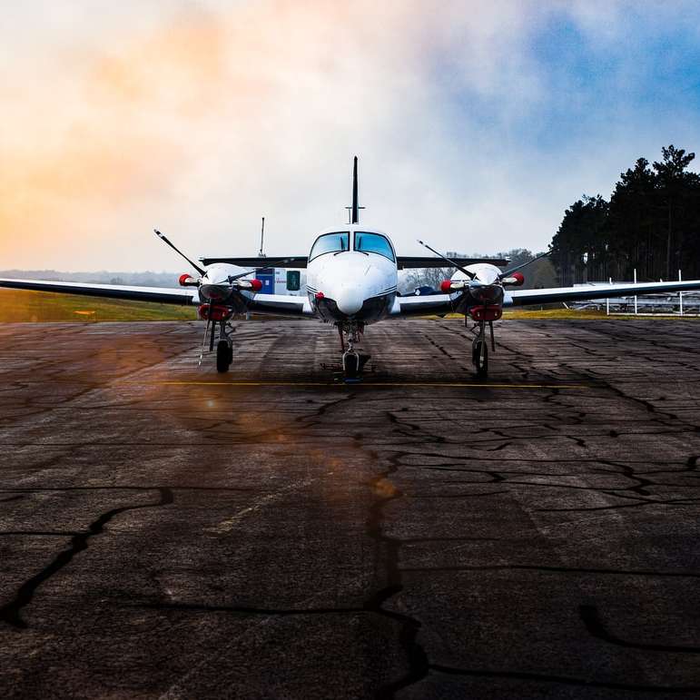 Biały samolot na brązowym polu pod szarymi chmurami puzzle przesuwne online