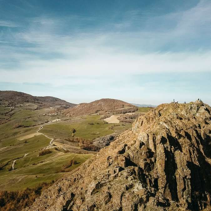 Bruine en groene berg onder blauwe hemel overdag schuifpuzzel online