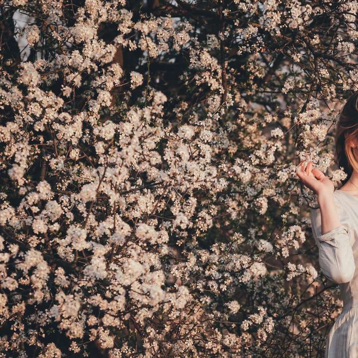Kvinna i vit klänning som står på bruna löv Pussel online