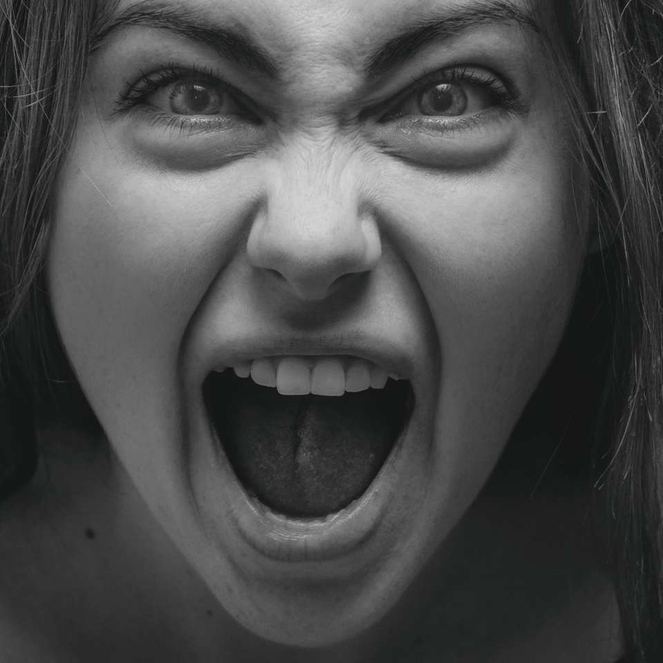 Foto en escala de grises de mujer que muestra su lengua. rompecabezas en línea