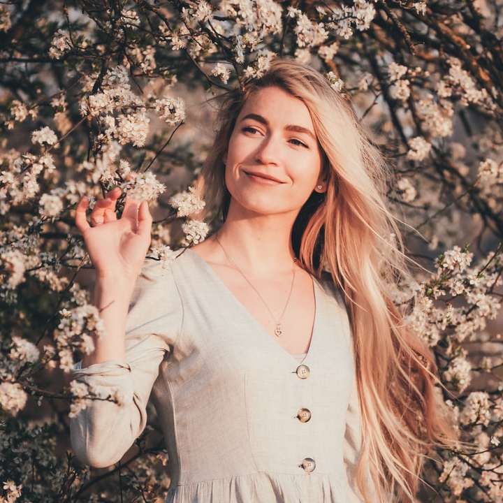 Frau im weißen langärmligen Hemd, das stehend und lächelt Schiebepuzzle online