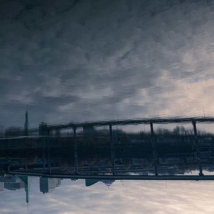 Svart metallbro under grå moln glidande pussel online