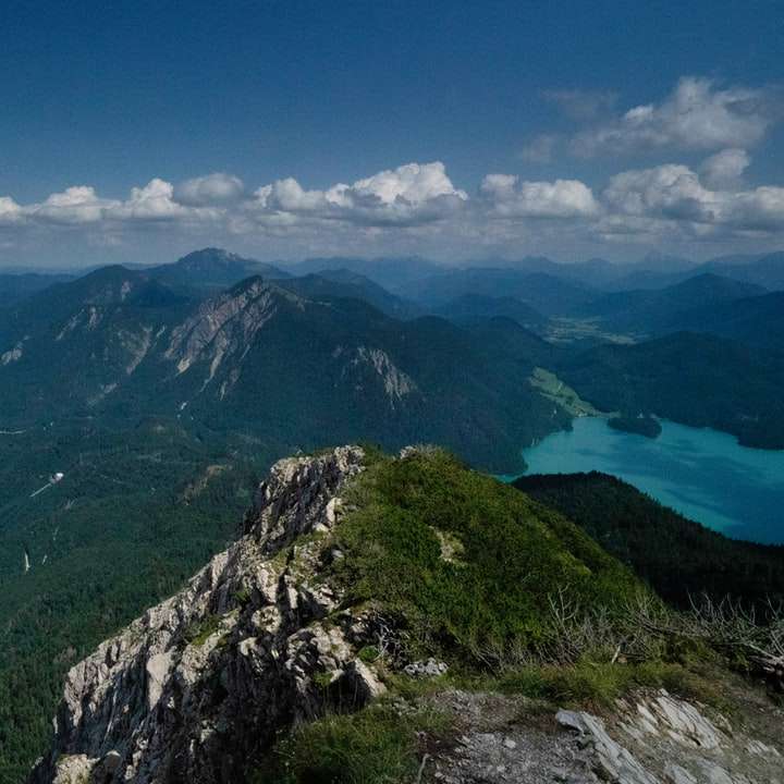 Zelené hory poblíž těla vody pod modrou oblohou posuvné puzzle online