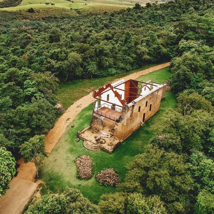 Braunes und weißes Holzhaus auf grüner Grasfeld Online-Puzzle