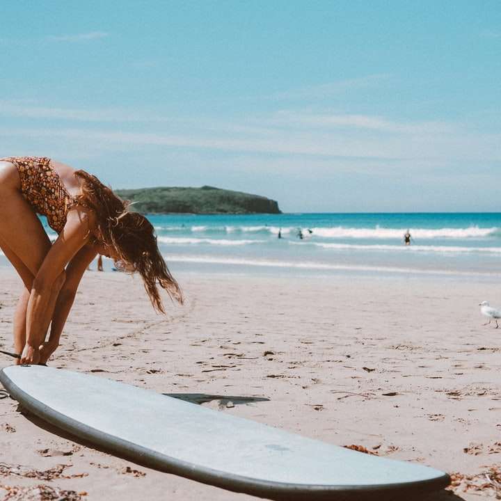 Donna in bikini marrone che cammina sulla spiaggia durante il giorno puzzle online