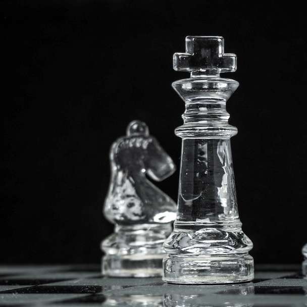 青いテーブルの上の透明なガラスのチェスの駒 スライディングパズル・オンライン