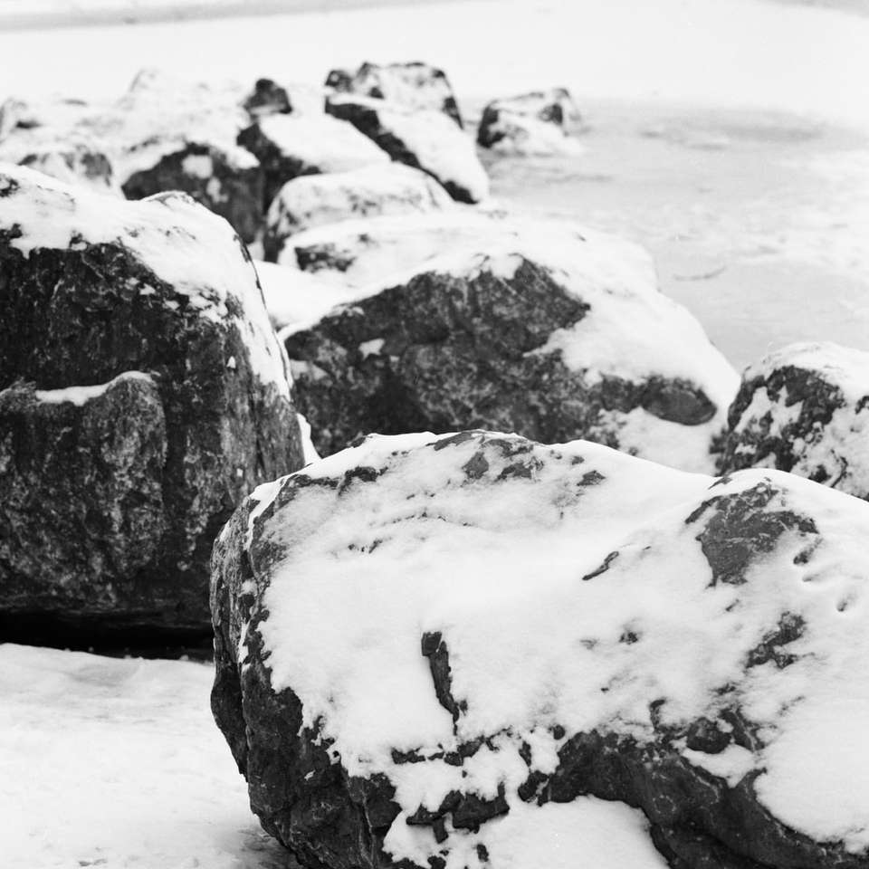 Formação de rocha cinza e preta na neve branca durante o dia puzzle online