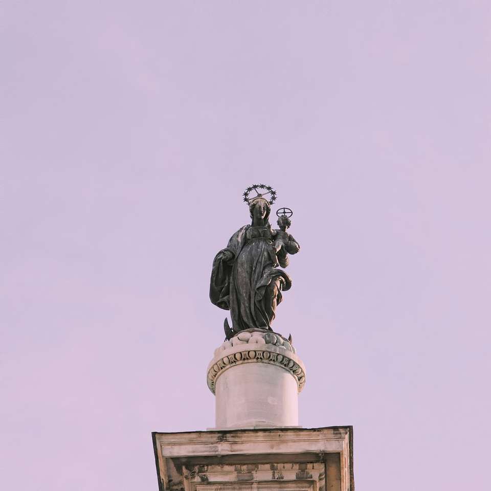 Svart staty av mannen ovanpå byggnaden Pussel online