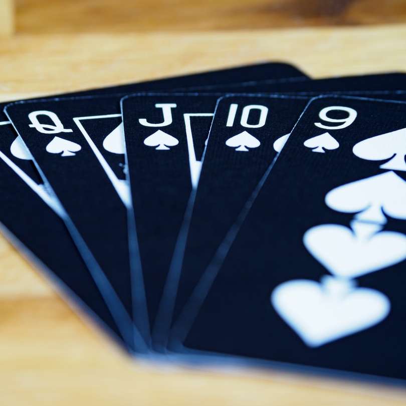 Carduri de joc alb-negru pe masa de lemn maro alunecare puzzle online
