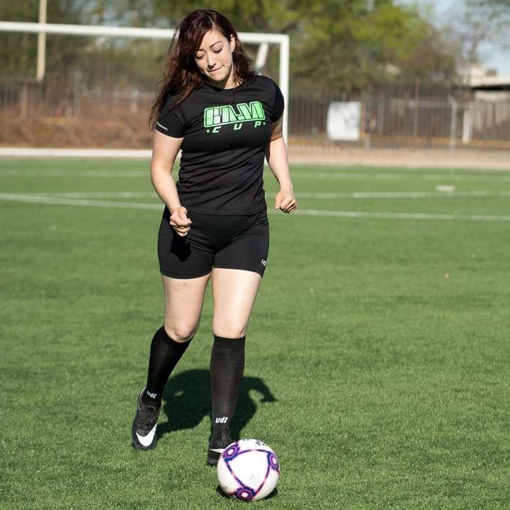 Mujer en negro Nike Soccer Jersey pateando el balón de fútbol puzzle deslizante online