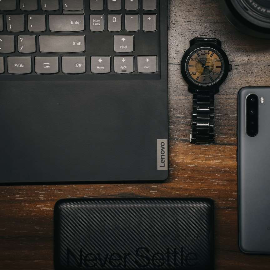 Ordenador portátil negro y plata al lado del reloj redondo negro rompecabezas en línea