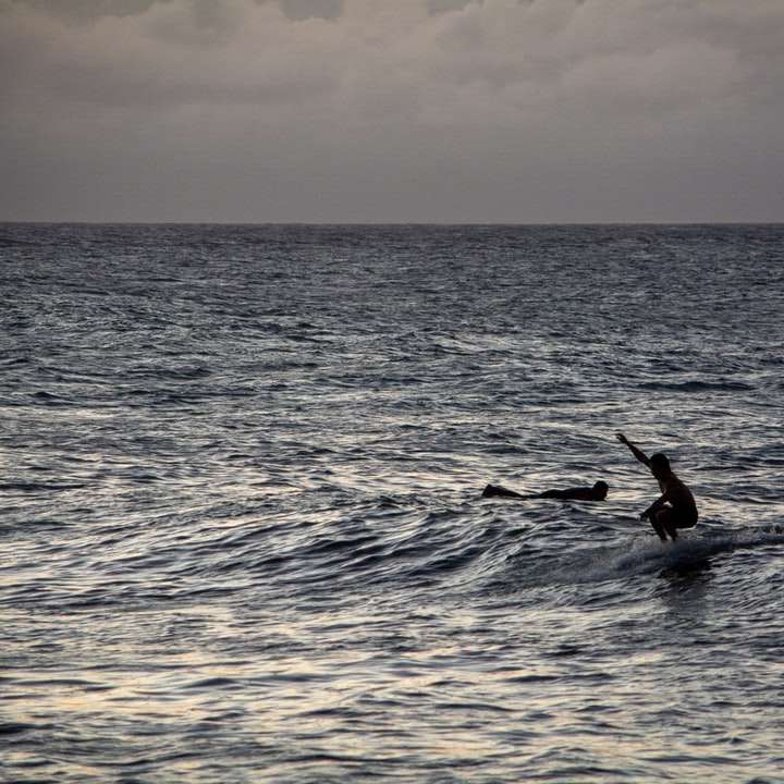 személy szörfözés a tenger hullámai napközben csúszó puzzle online