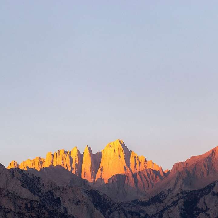 Montanhas rochosas marrons sob o céu branco durante o dia puzzle online