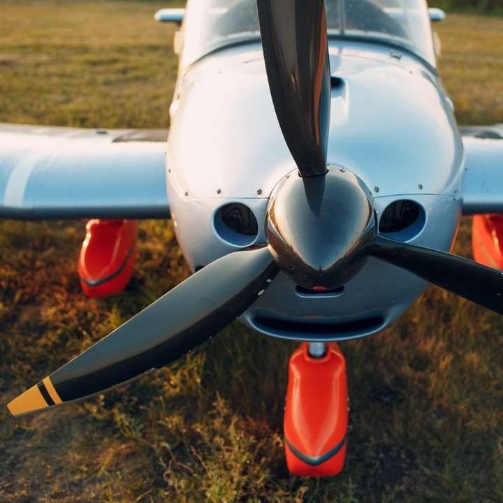 Vitt och rött flygplan på brunt fält under dagtid Pussel online