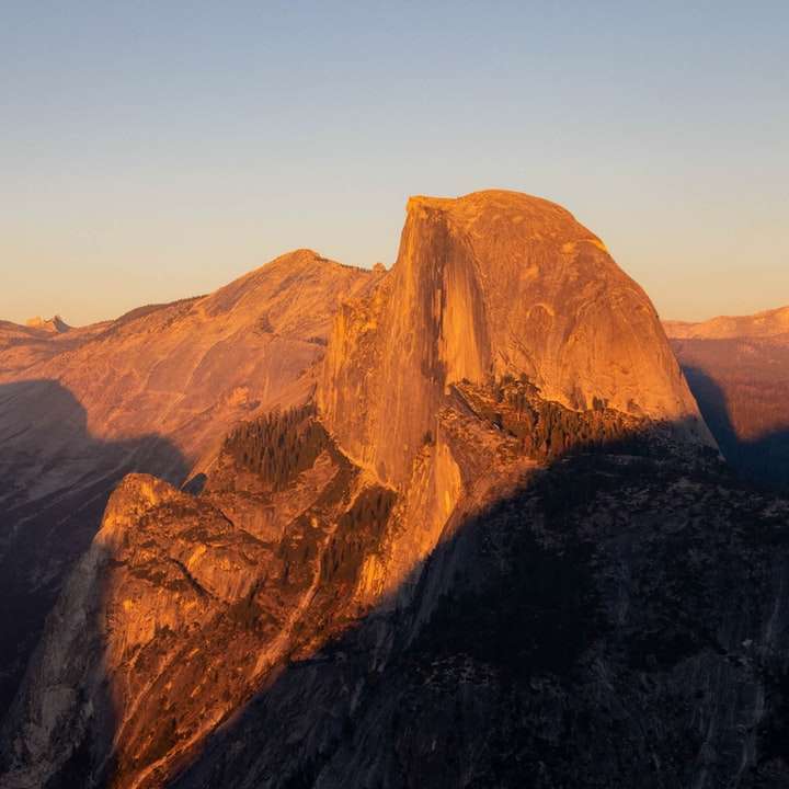 Montagna rocciosa marrone sotto il cielo blu durante il giorno puzzle scorrevole online