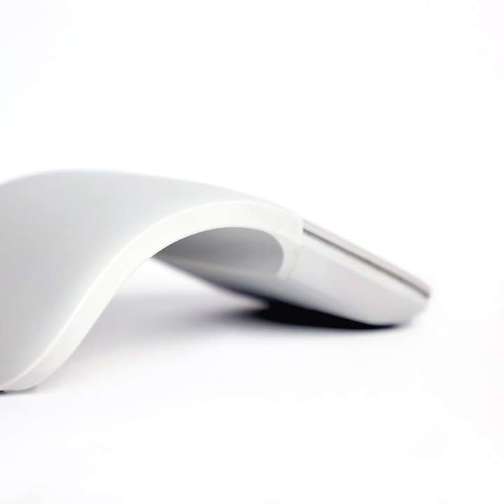Zwarte Apple Magic Mouse op wit oppervlak schuifpuzzel online