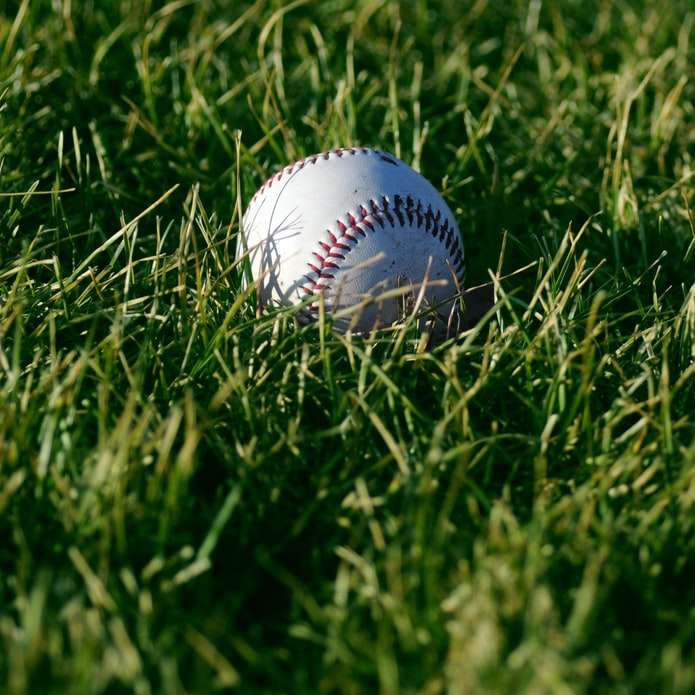 Biały baseball na zielonej trawie w ciągu dnia puzzle online