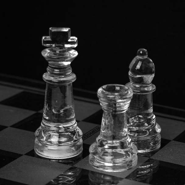 Peça de xadrez de vidro claro na mesa quadriculada preto e branco puzzle online