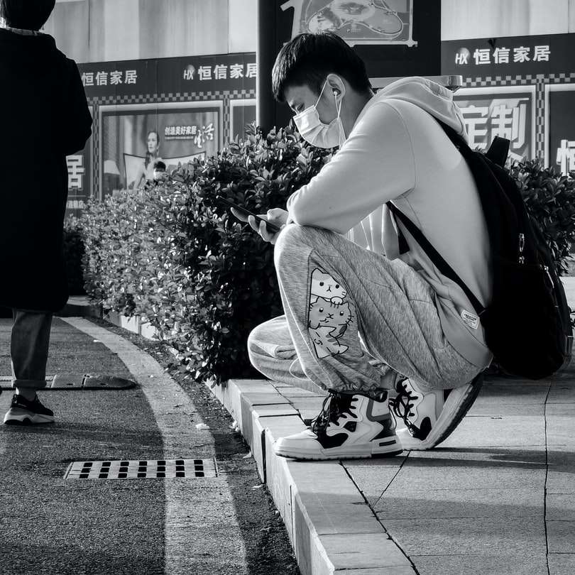Γυναίκα σε λευκό πουκάμισο και μαύρα παντελόνια που κάθεται στο πεζοδρόμιο συρόμενο παζλ online