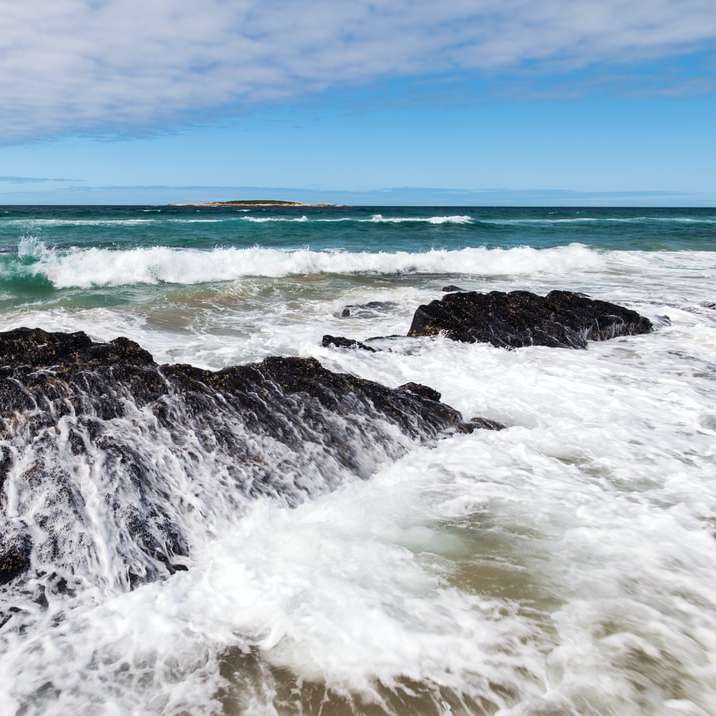 Ocean Waves kraschar på stranden under dagtid Pussel online
