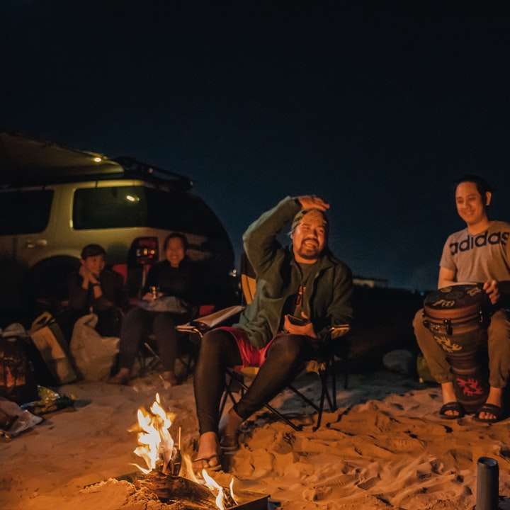 Група от хора, седящи на кафяв дървен дневник онлайн пъзел