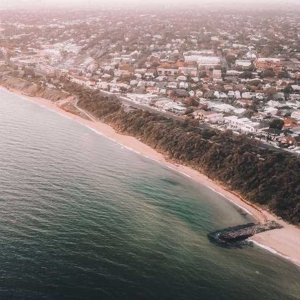 Въздушна гледка към морските вълни се разбиват на брега през деня плъзгащ се пъзел онлайн