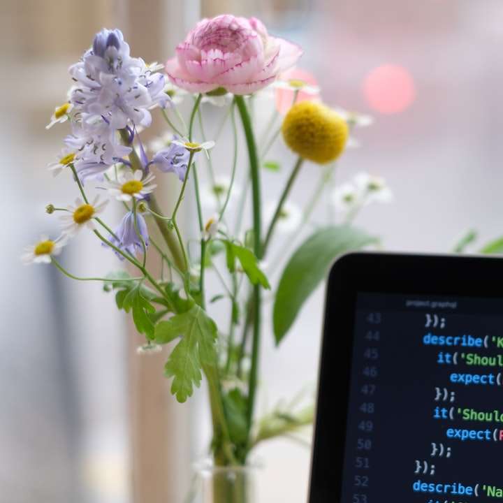 Zwarte laptop computer ingeschakeld in de buurt van gele bloemen schuifpuzzel online
