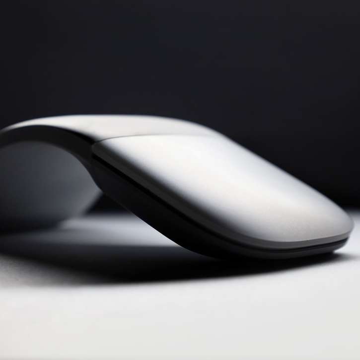 Λευκό ασύρματο ποντίκι υπολογιστή σε λευκή επιφάνεια συρόμενο παζλ online