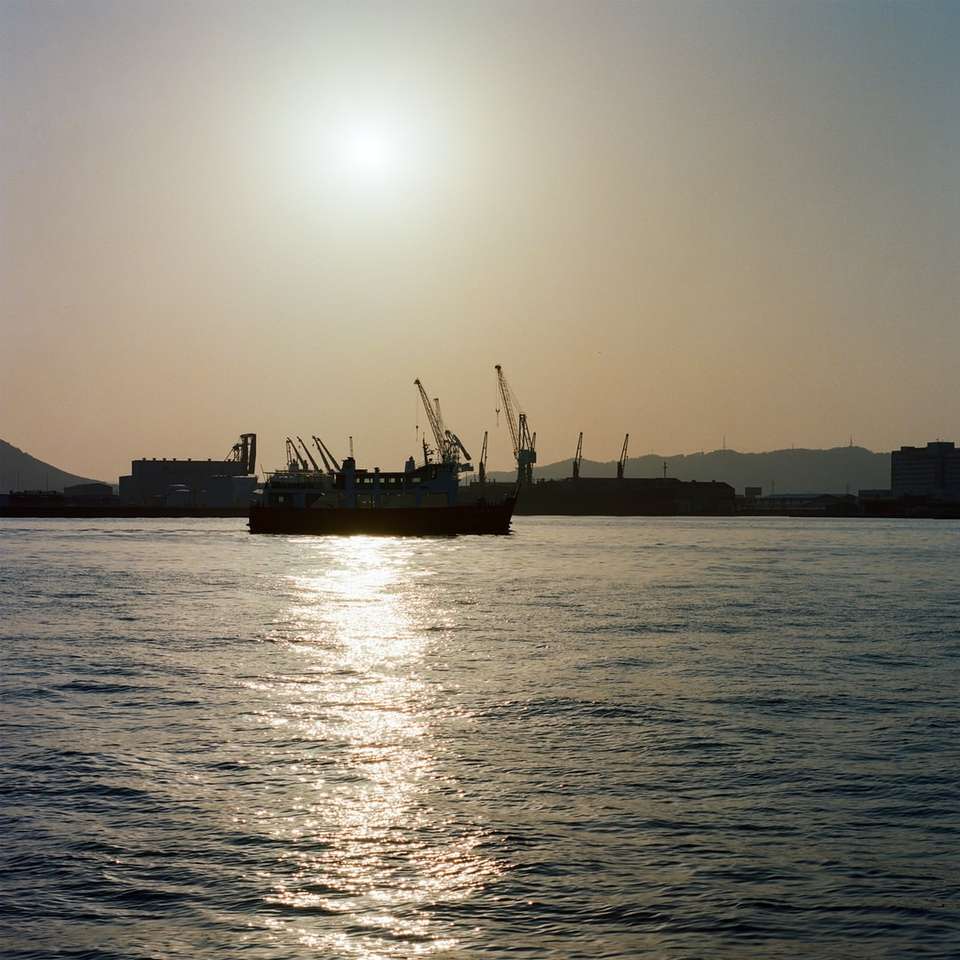 Silhouette de navire sur la mer au coucher du soleil puzzle coulissant en ligne