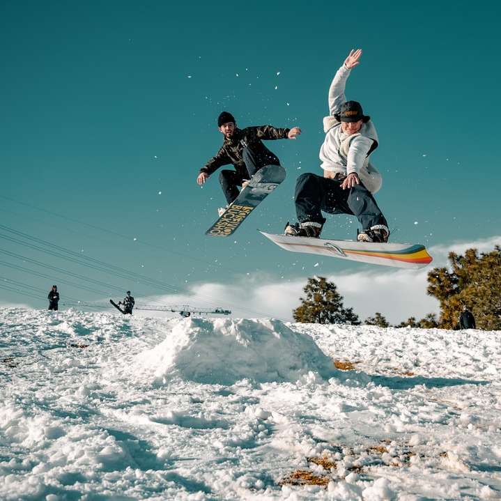 Mann in der schwarzen und weißen Jacke, die auf Snowboard fahren Schiebepuzzle online