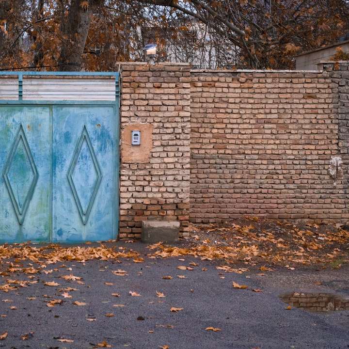 Blauwe houten deur op bruine bakstenen muur schuifpuzzel online