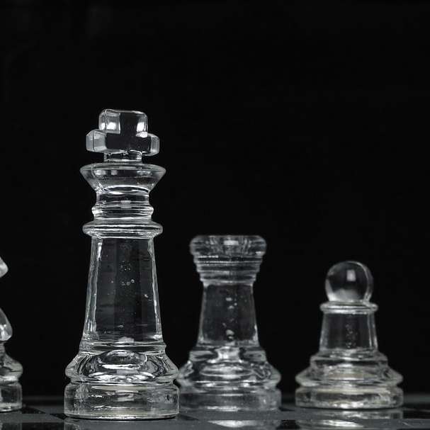Pieza de ajedrez de cristal transparente sobre superficie negra rompecabezas en línea
