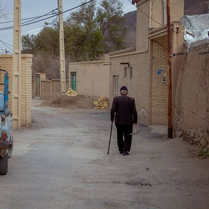 Homem de jaqueta preta em pé ao lado do carro branco durante o dia puzzle deslizante online