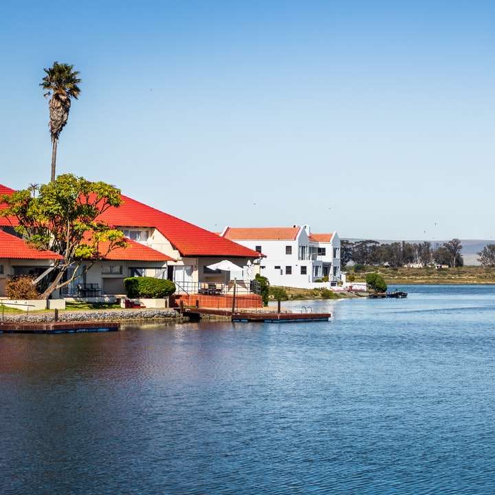 Fehér és barna házak a víztest közelében nappali online puzzle