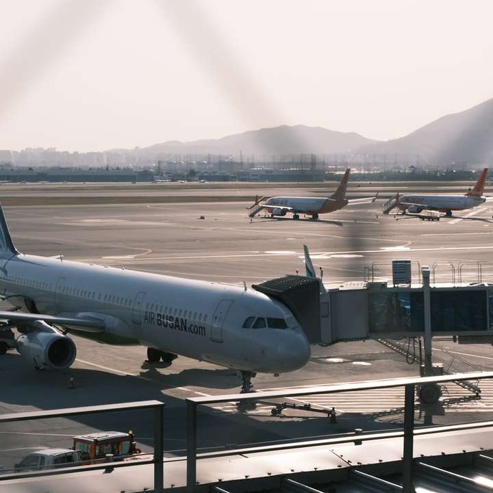 Biały samolot pasażerski na lotnisku w ciągu dnia puzzle przesuwne online