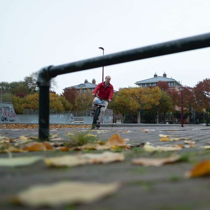 Omul în jachetă roșie și pantaloni negri care rulează pe drum alunecare puzzle online