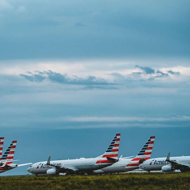 Wit en rood vliegtuig onder witte wolken en blauwe hemel schuifpuzzel online