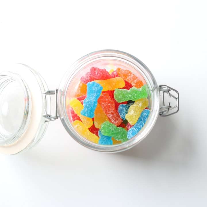 Jar en verre clair avec de la nourriture rouge et jaune puzzle coulissant en ligne