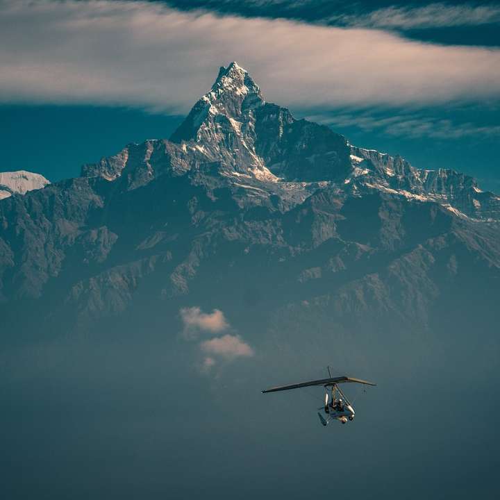 Черный вертолет пролетел над заснеженной горой онлайн-пазл
