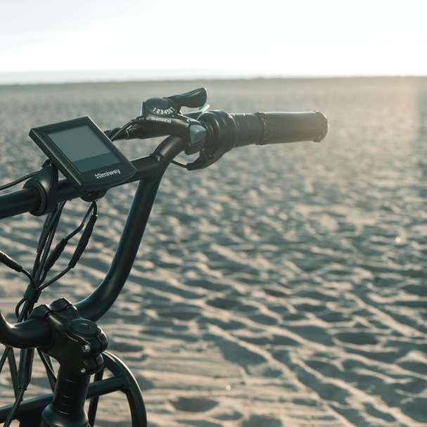 Câmera preta no tripé preto na areia marrom durante o dia puzzle deslizante online